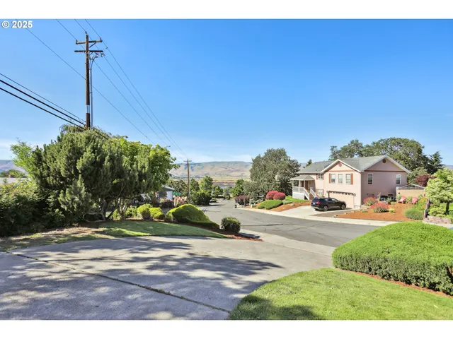 a front view of a house with a yard and potted plants