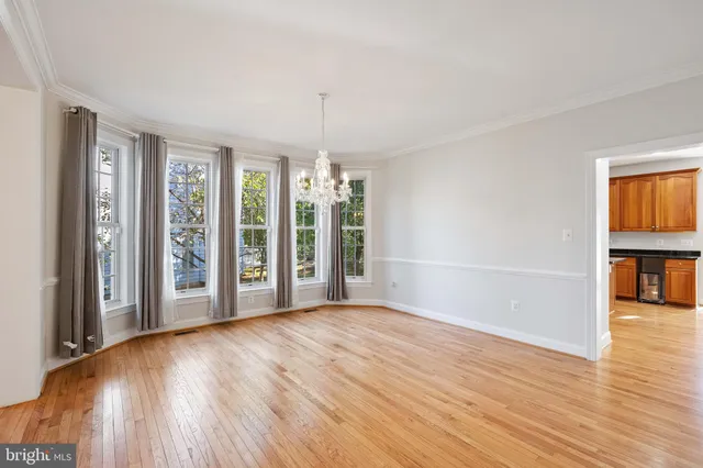 a view of a big room with wooden floor and chandelier