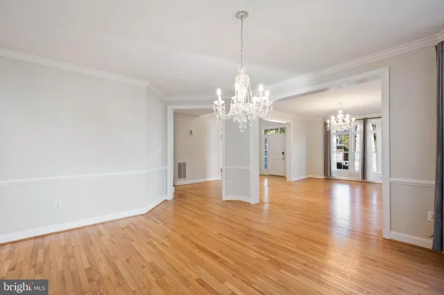 a view of an empty room with glass door and wooden floor