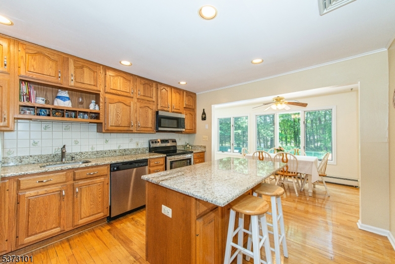 10 Campo Road Randolph, NJ 07869 - Photo 13 of 49 a kitchen with stainless steel appliances granite countertop a stove top oven a sink dishwasher and wooden cabinets with wooden floor