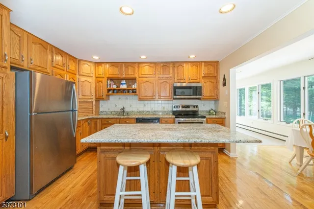 a kitchen with stainless steel appliances granite countertop a sink and a refrigerator