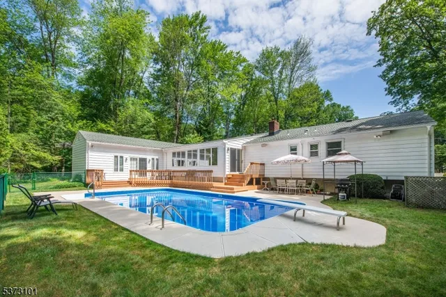 a view of a house with pool and a yard