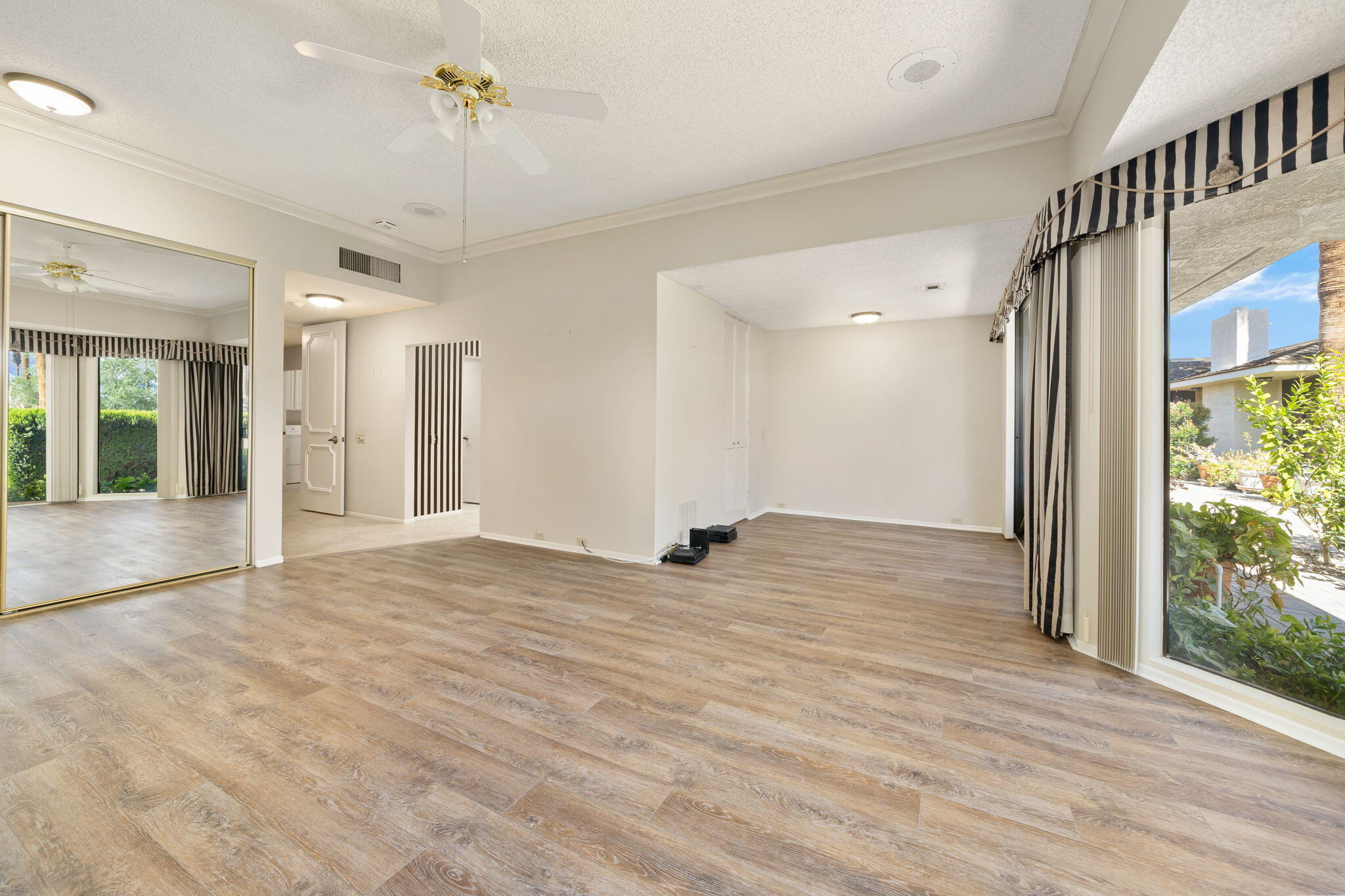140 Columbia Drive Rancho Mirage, CA 92270 - Photo 16 of 31 a view of empty room with wooden floor and fan