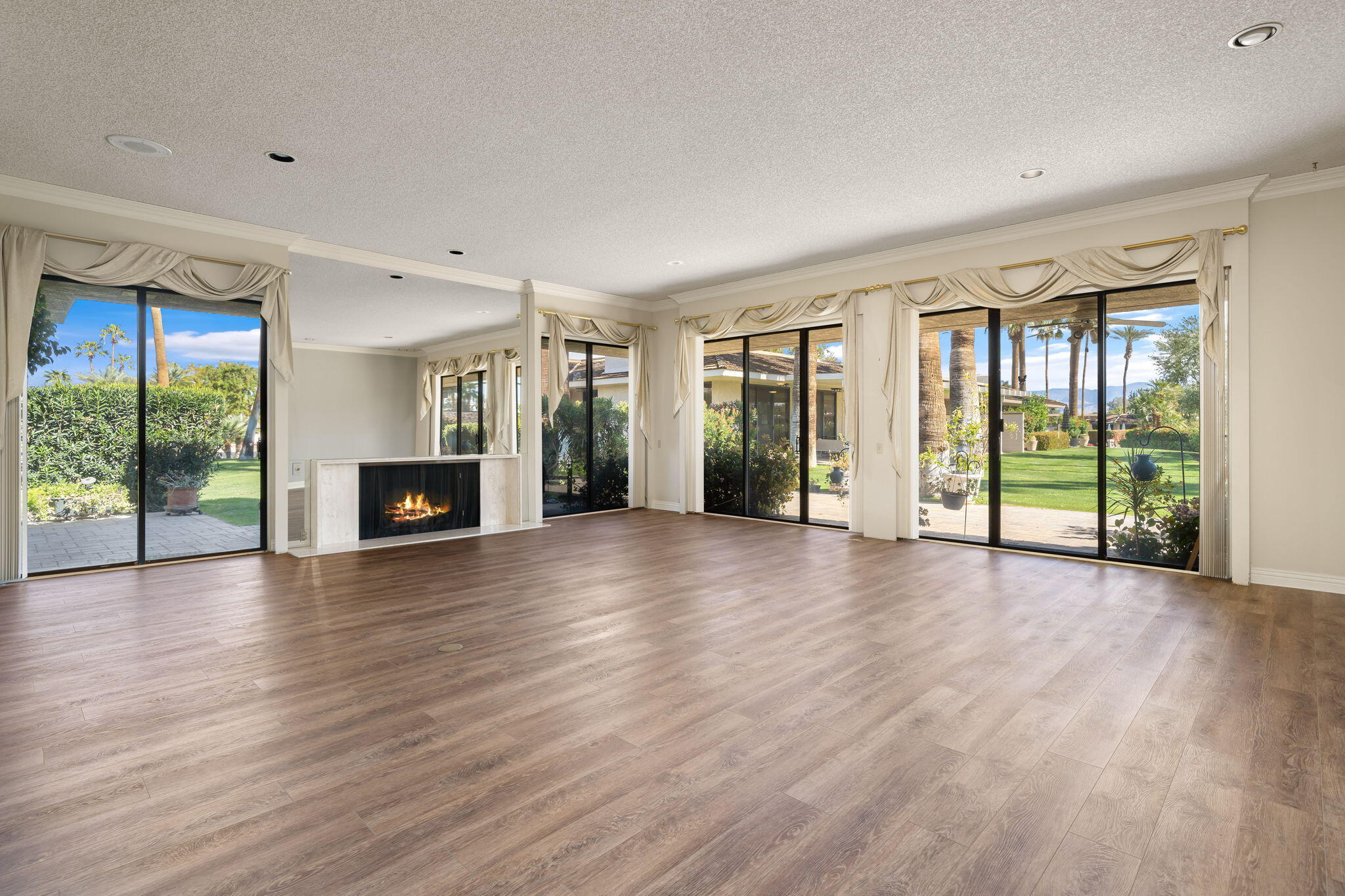 140 Columbia Drive Rancho Mirage, CA 92270 - Photo 3 of 31 a view of an empty room with wooden floor and a fireplace