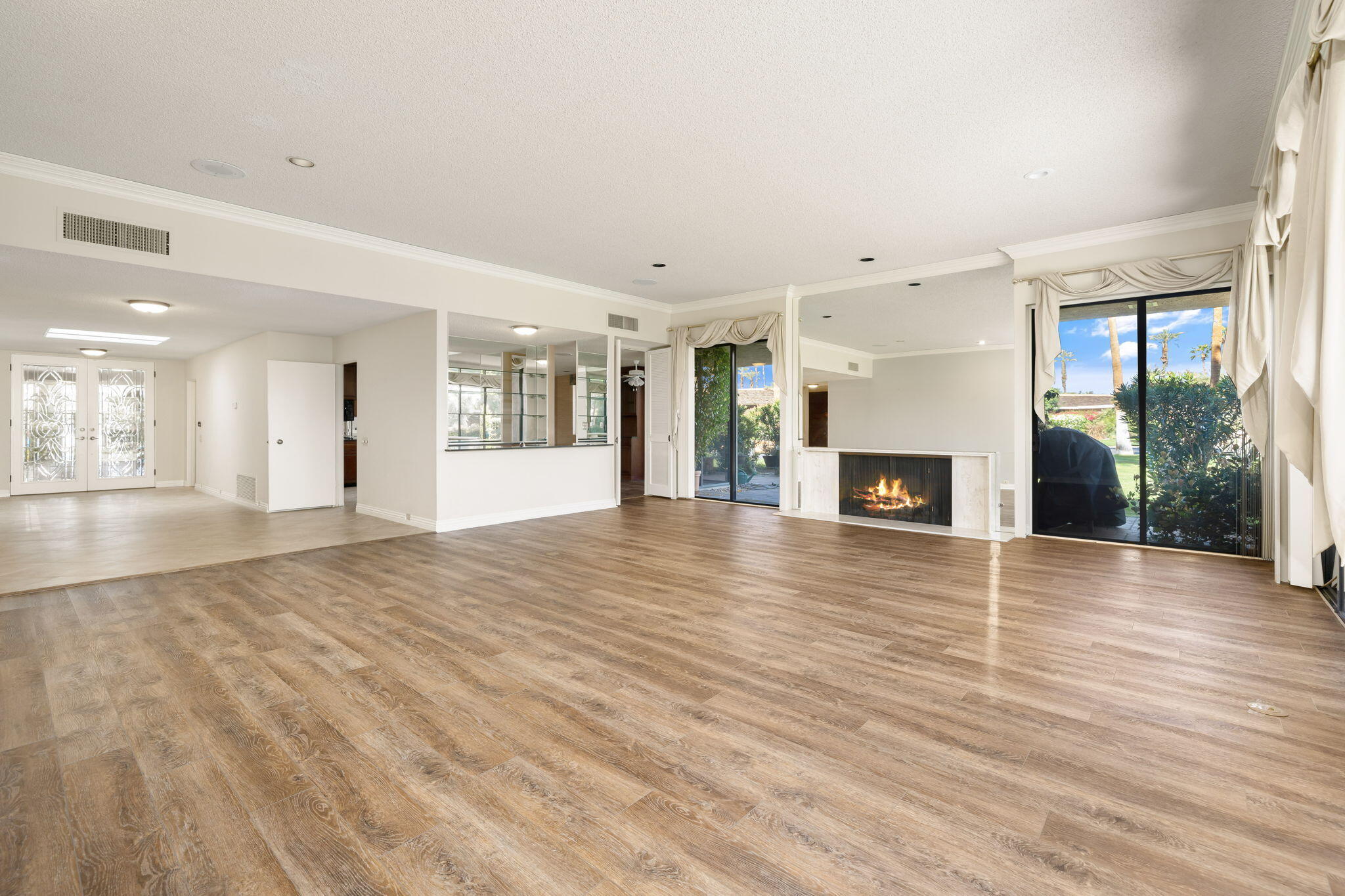 140 Columbia Drive Rancho Mirage, CA 92270 - Photo 4 of 31 an empty room with wooden floor and a fireplace