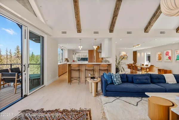 a living room with furniture a large window and a chandelier