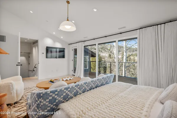 a bedroom with a bed couch and window