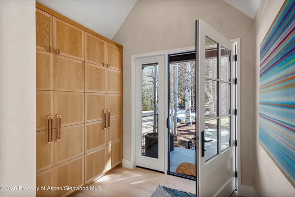 a living room with furniture a mirror and a glass door