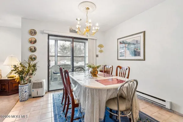 a view of a dining room with furniture a chandelier and wooden floor