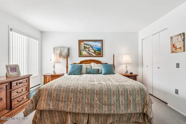 a bedroom with a bed and a painting on the wall