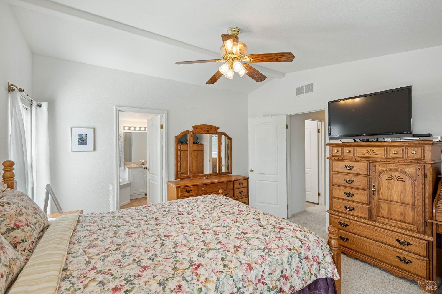 6468 Washington Street, Unit 16 Yountville, CA 94599 - Photo 26 of 45 a bedroom with a bed and a flat tv screen on dresser
