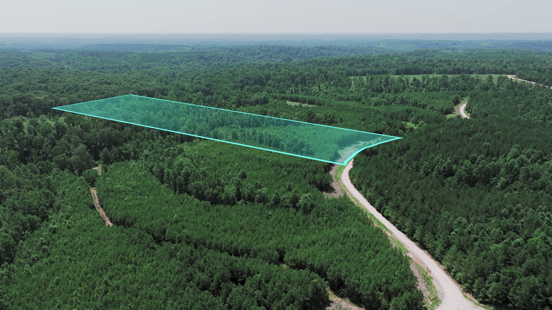 a view of a green field with a wooden fence