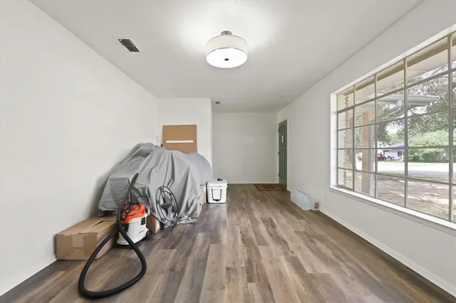 a view of gym equipment with wooden floor and windows