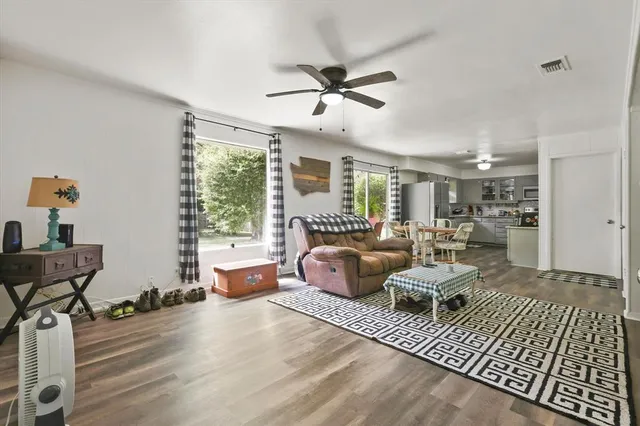 a living room with furniture floor to ceiling window and wooden floor