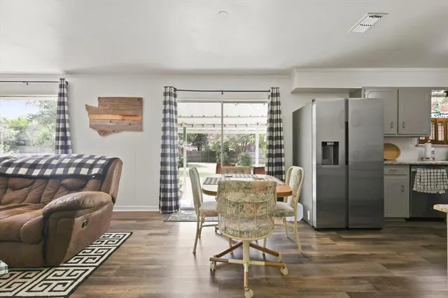 a living room with furniture and a refrigerator