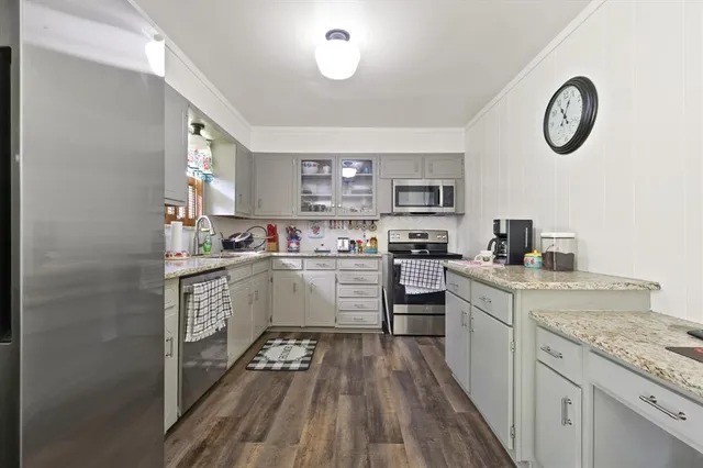 a kitchen with a refrigerator and a stove top oven