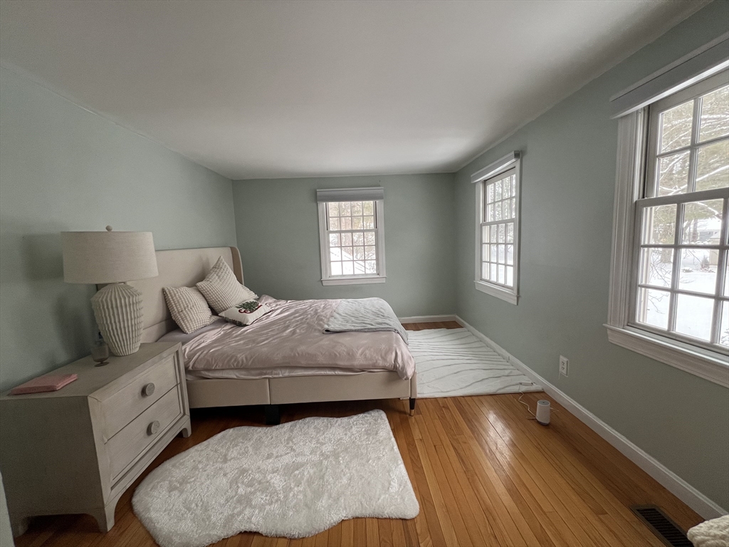 68 Jericho Road, Unit 68 Weston, MA 02493 - Photo 1 of 1 a bedroom with a bed and wooden floor