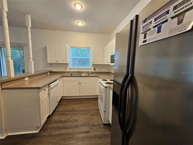 a kitchen with stainless steel appliances a sink a stove a refrigerator and cabinets
