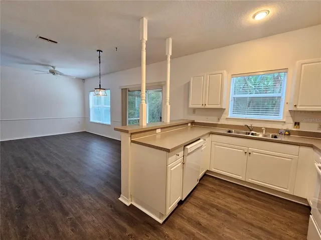 a open kitchen with stainless steel appliances granite countertop a sink a window and wooden floor