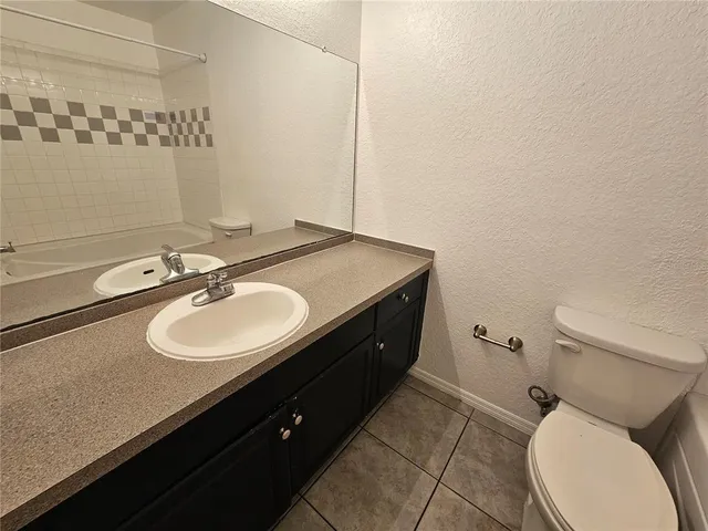 a bathroom with a granite countertop sink toilet a mirror and shower
