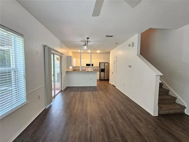 a view of a kitchen with wooden floor and electronic appliances