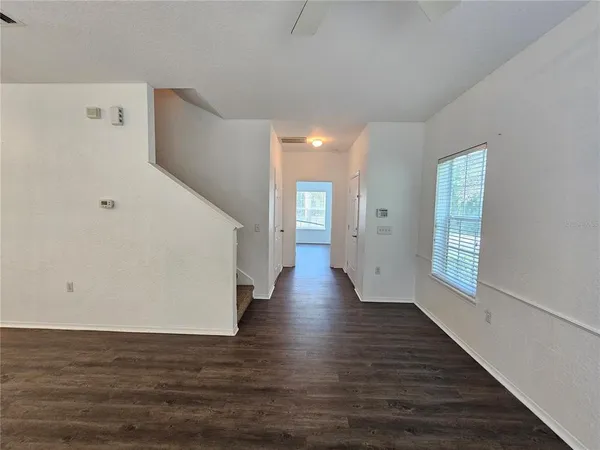 a view of a big room with wooden floor and windows