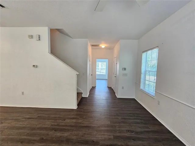 a view of a big room with wooden floor and windows
