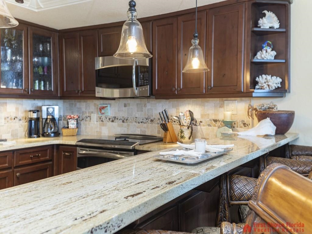 1 Dondanville Road, Unit 109B St. Augustine, FL 32080 - Photo 8 of 27 a kitchen with granite countertop a stove a sink and a microwave