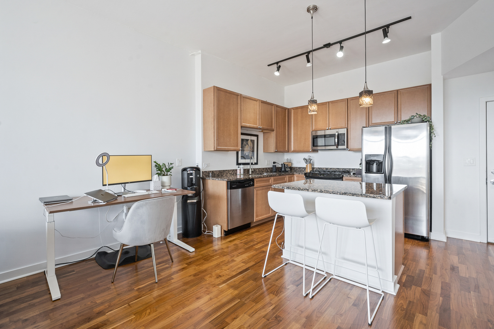 901 West Madison Street, Unit 401 Chicago, IL 60607 - Photo 5 of 19 a living room with couches kitchen island and a dining table with wooden floor