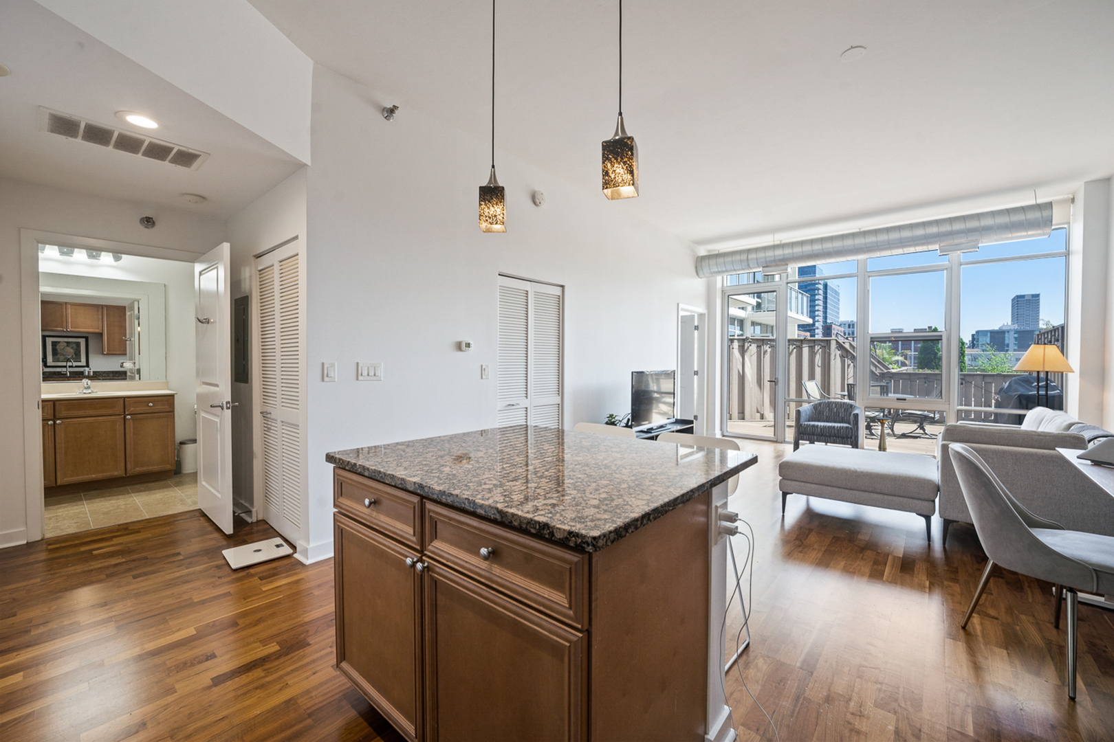 901 West Madison Street, Unit 401 Chicago, IL 60607 - Photo 7 of 19 a kitchen with a center island wooden floor and a view of living room