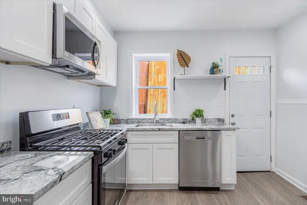 a kitchen with stainless steel appliances granite countertop a stove and a sink