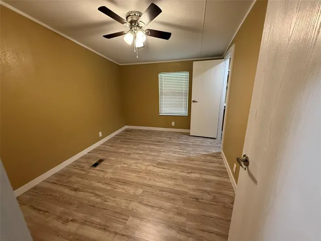 a view of a big room with wooden floor and windows