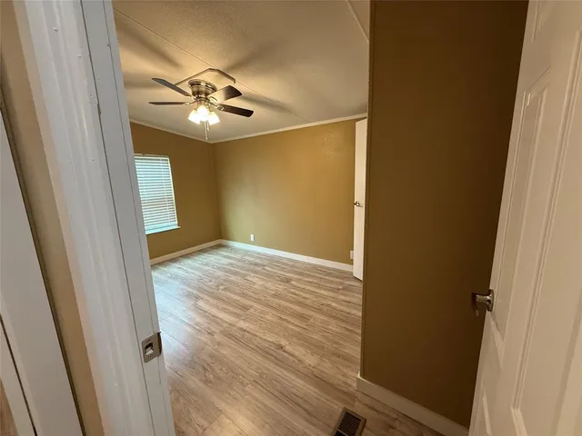 a view of empty room with wooden floor