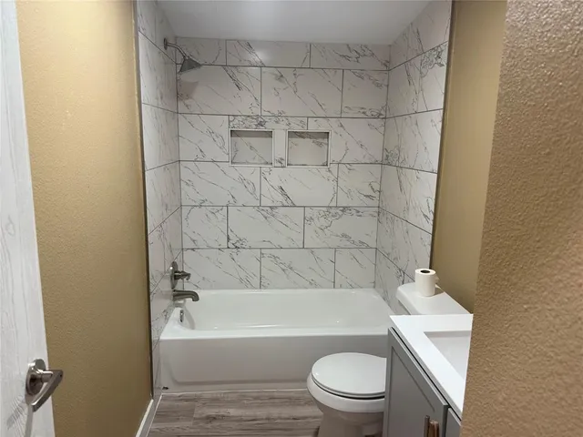 a bathroom with a toilet and a bath tub