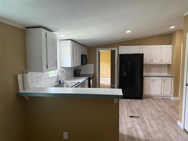 a kitchen with kitchen island a sink appliances and a refrigerator
