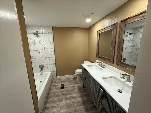 a bathroom with a double vanity sink a toilet and mirror