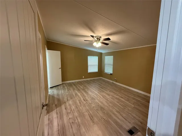 a view of empty room with wooden floor