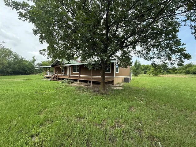 a view of a house with backyard and sitting area