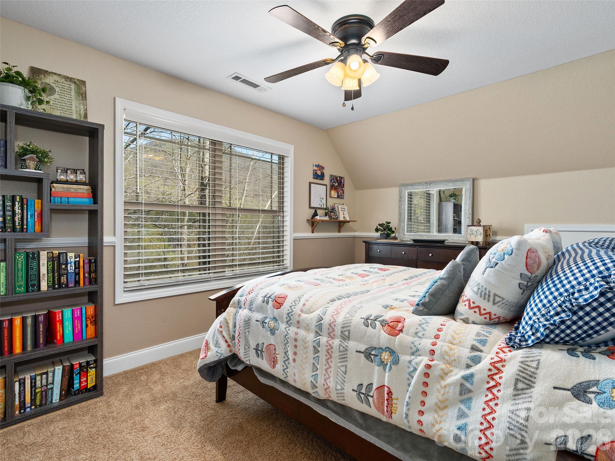4823 Max Patch Road Clyde, NC 28721 - Photo 26 of 32 a bedroom with a bed a book shelf and a window