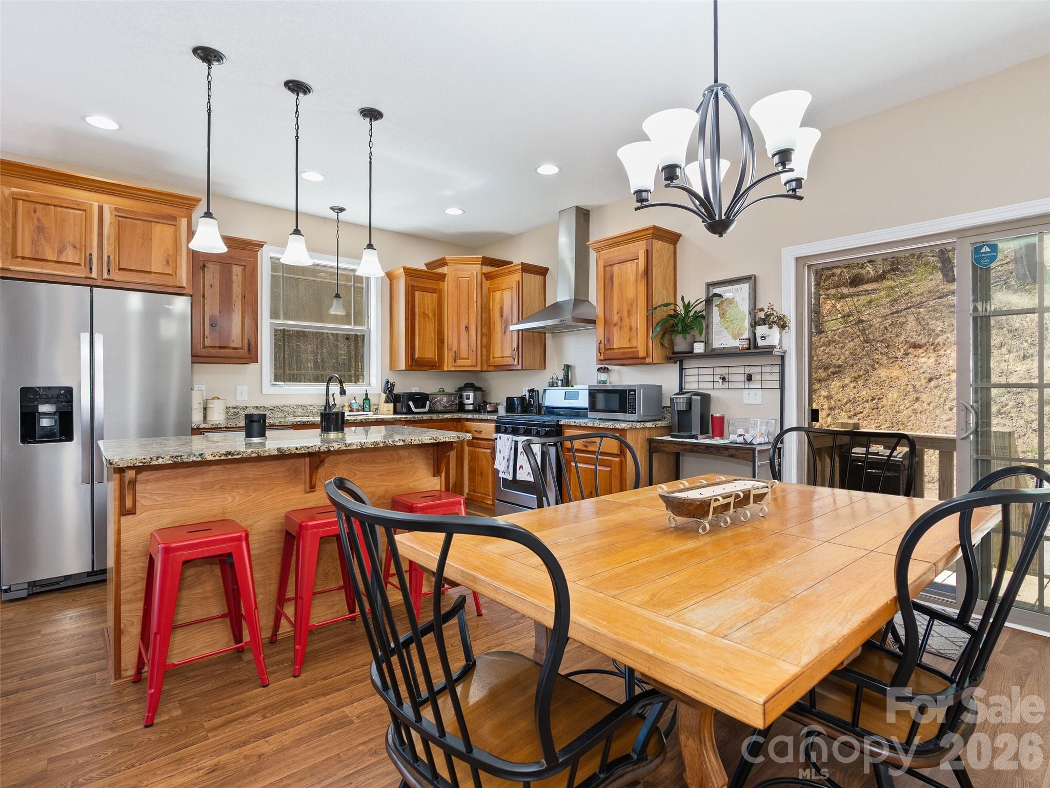 4823 Max Patch Road Clyde, NC 28721 - Photo 3 of 32 a very nice looking kitchen with stainless steel appliances granite countertop a table chairs and a chandelier
