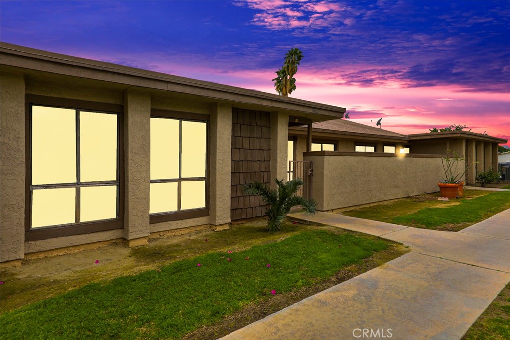 45546 Aladdin Street, Unit B101 Indio, CA 92201 - Photo 1 of 18 a front view of a house with a yard