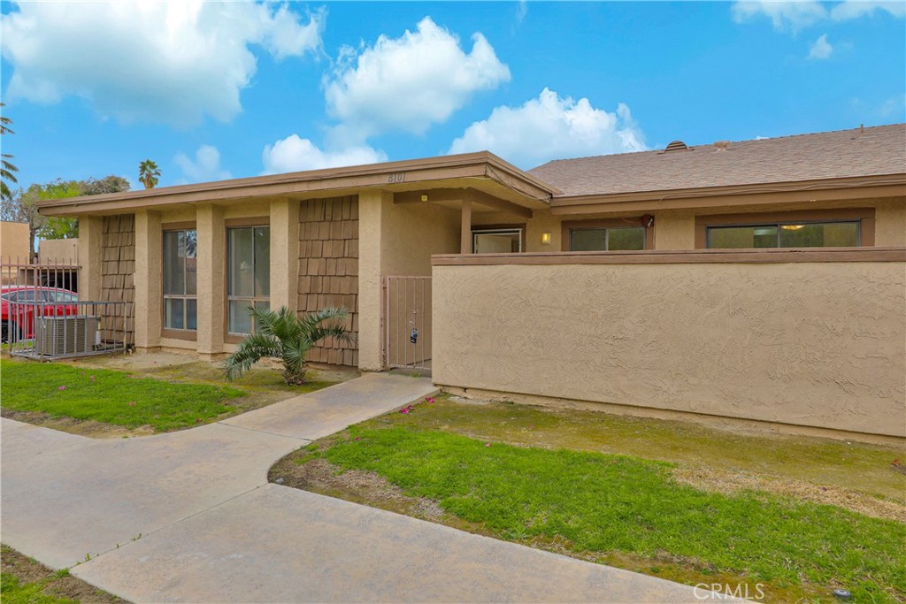45546 Aladdin Street, Unit B101 Indio, CA 92201 - Photo 2 of 18 a front view of a house with a garden