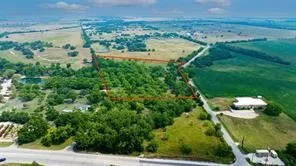 an aerial view of residential houses with outdoor space and trees