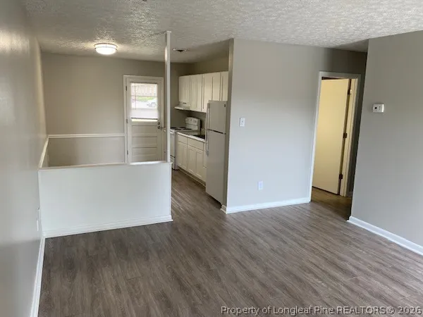 a view of a kitchen with wooden floor and a refrigerator
