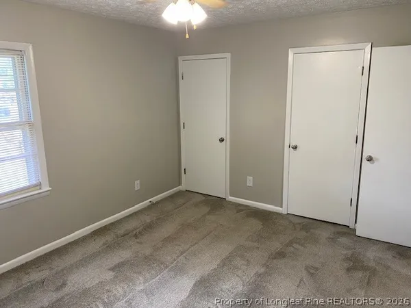an empty room with windows and closet