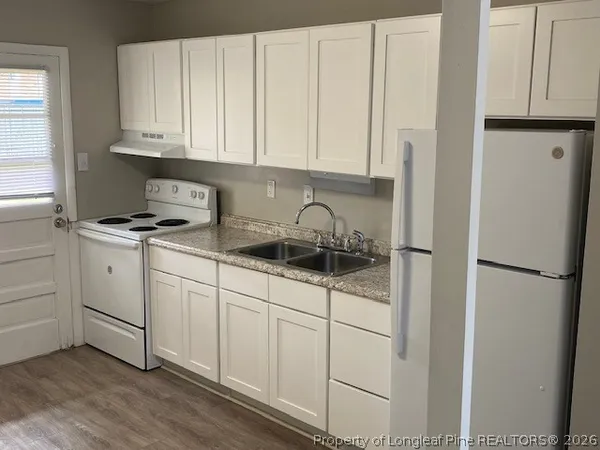 a kitchen with white cabinets and white appliances