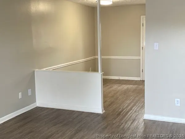 a view of an empty walk in closet with wooden floor
