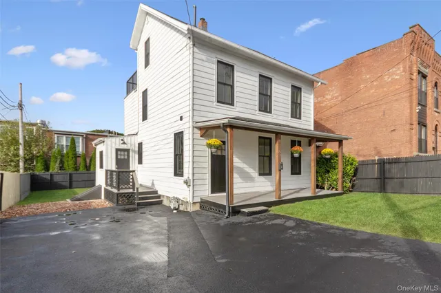 a view of a white house with many windows next to a road