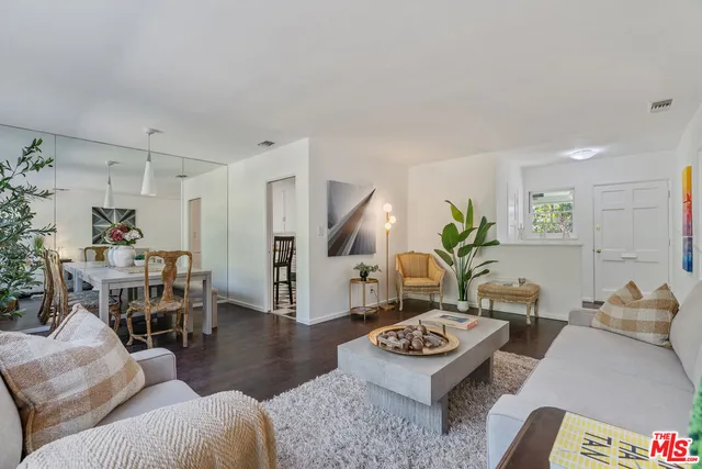 a living room with furniture potted plant and a table