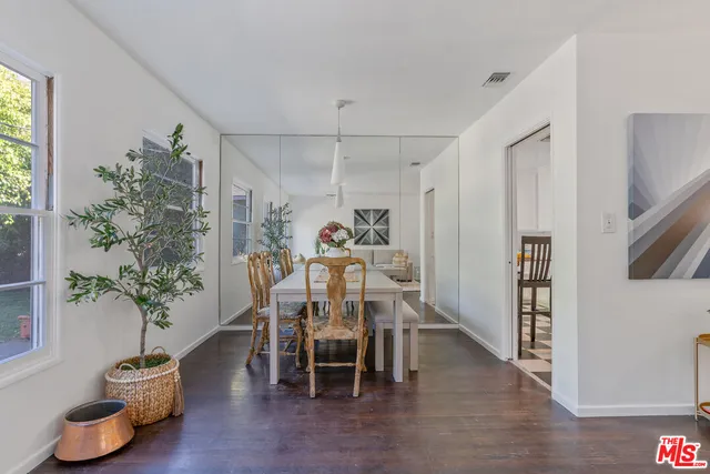 a dining room with furniture potted plants and wooden floor